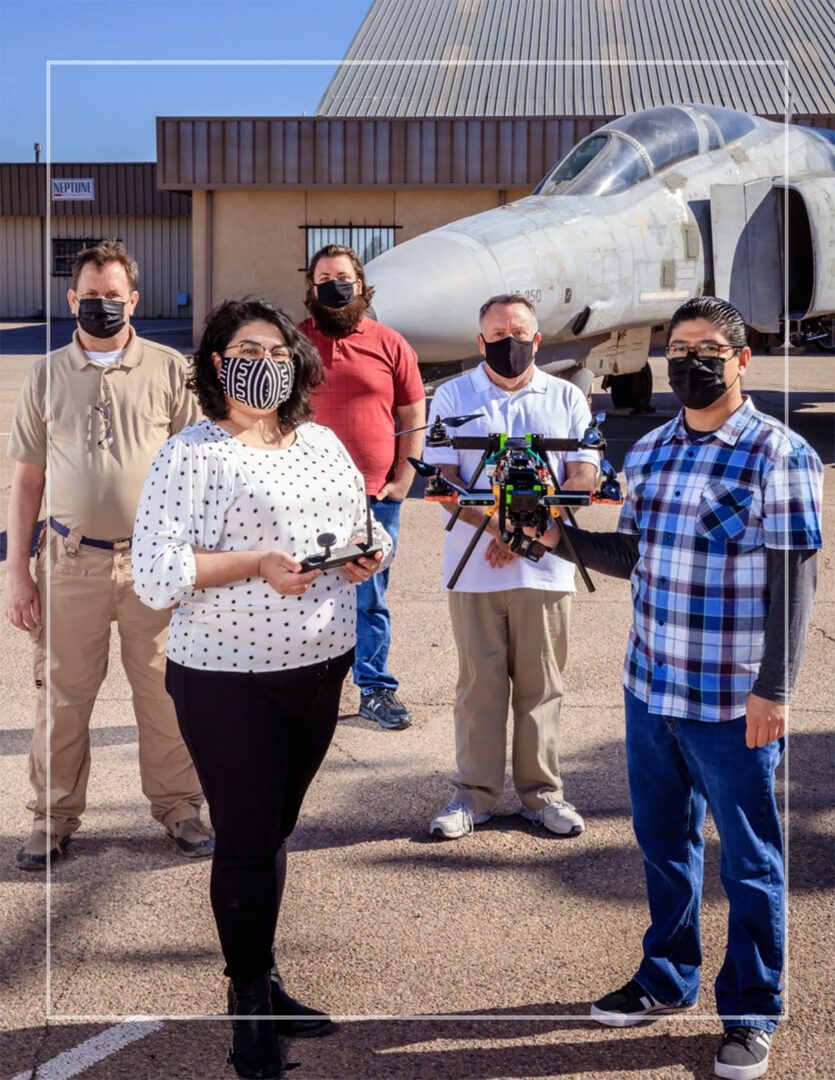A group of people standing in front of an airplane.