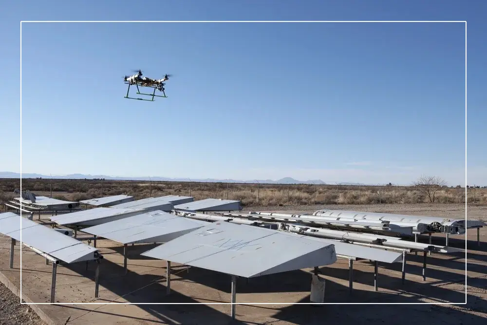 A solar panel array with a flying device in the air.