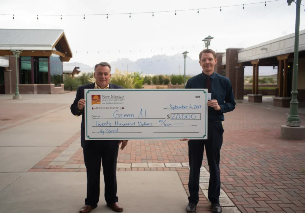 Two men holding a large check in front of them.